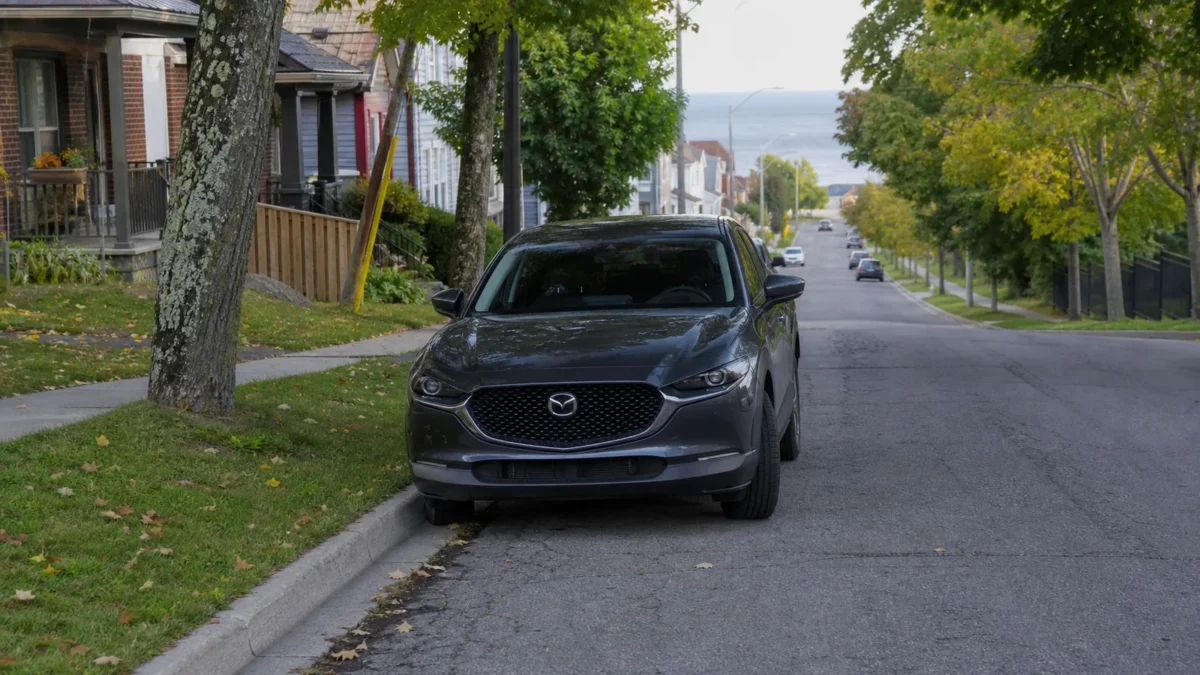 A car parked on a sloped Ontario street with its front wheels turned toward the curb.